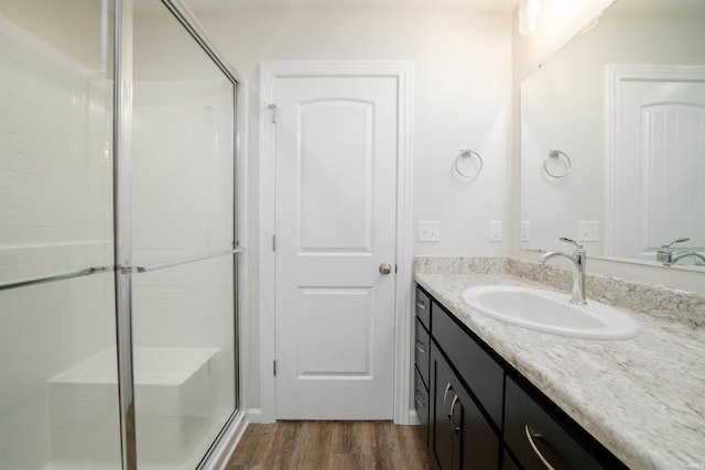 bathroom with vanity, hardwood / wood-style floors, and a shower with shower door