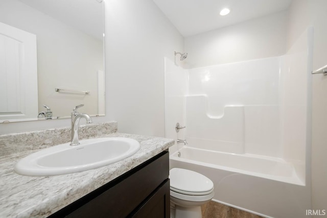 full bathroom with vanity, hardwood / wood-style floors, shower / tub combination, and toilet