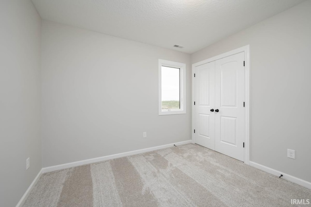 carpeted spare room with a textured ceiling