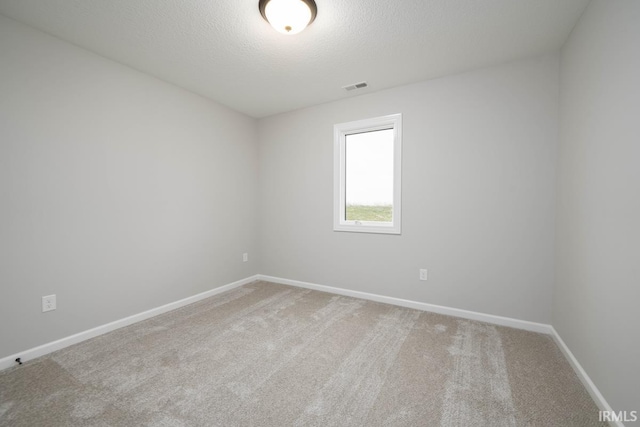 unfurnished room featuring a textured ceiling and carpet