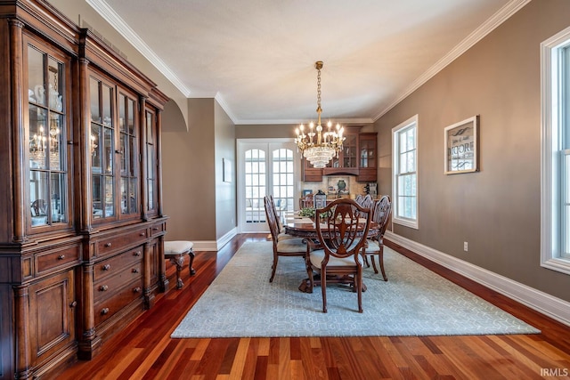 dining area featuring dark hardwood / wood-style flooring, an inviting chandelier, and ornamental molding