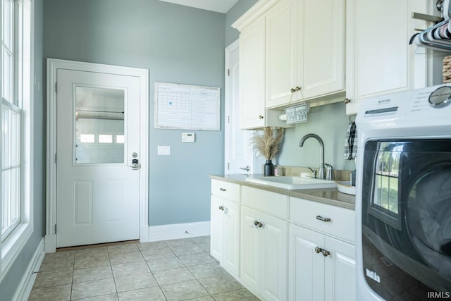 washroom with cabinets, sink, washer / dryer, and light tile flooring