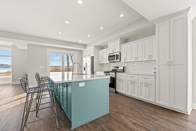 51 Ln 345 Crooked Lk, Angola, IN 46703 - kitchen featuring a breakfast bar, white cabinets, dark hardwood / wood-style flooring, appliances with stainless steel finishes, and a center island with sink