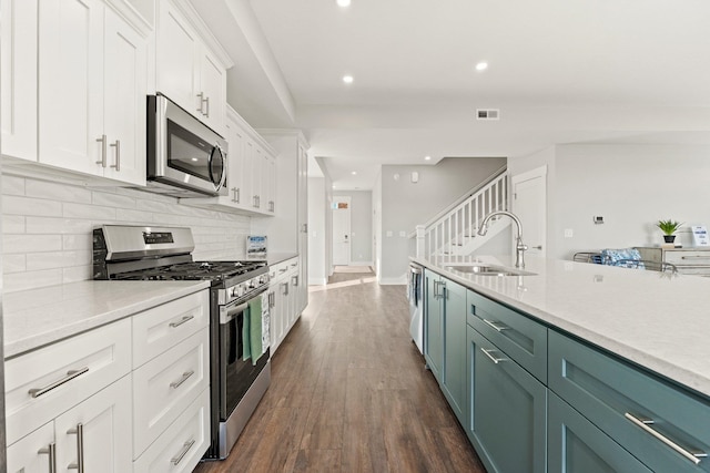 51 Ln 345 Crooked Lk, Angola, IN 46703 - kitchen featuring appliances with stainless steel finishes, white cabinets, sink, backsplash, and dark hardwood / wood-style floors