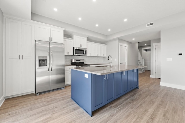 39 Ln 345 Crooked Lk, Angola, IN 46703 - kitchen featuring light hardwood / wood-style flooring, white cabinetry, backsplash, stainless steel appliances, and an island with sink