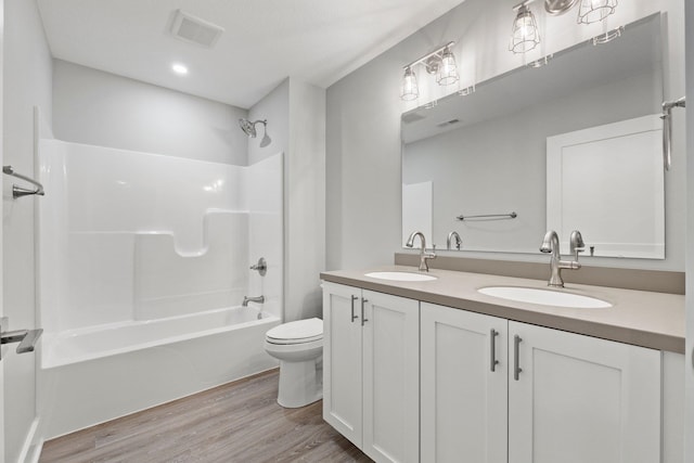 19 Ln 345 Crooked Lk, Angola, IN 46703 - full bathroom featuring dual bowl vanity, toilet, a textured ceiling, shower / bathing tub combination, and hardwood / wood-style flooring