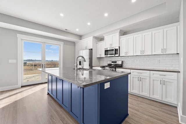 19 Ln 345 Crooked Lk, Angola, IN 46703 - kitchen with white cabinetry, appliances with stainless steel finishes, sink, light hardwood / wood-style floors, and an island with sink