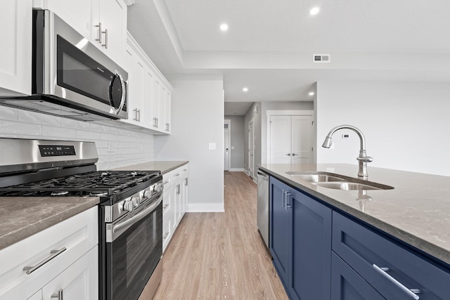 19 Ln 345 Crooked Lk, Angola, IN 46703 - kitchen featuring blue cabinetry, appliances with stainless steel finishes, backsplash, light hardwood / wood-style floors, and white cabinets