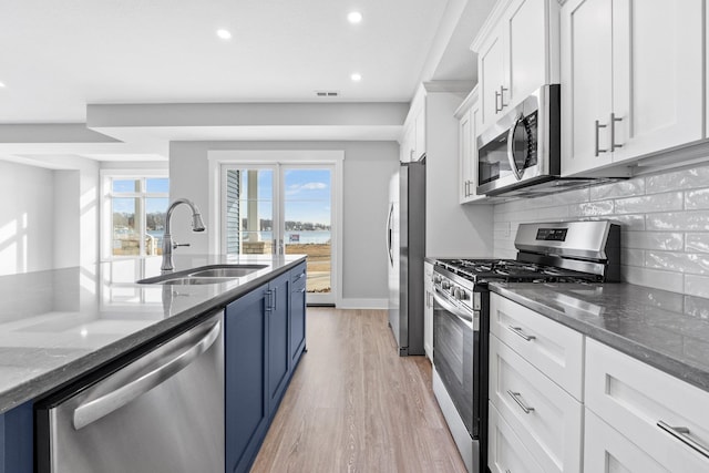 19 Ln 345 Crooked Lk, Angola, IN 46703 - kitchen featuring sink, tasteful backsplash, light wood-type flooring, white cabinetry, and stainless steel appliances