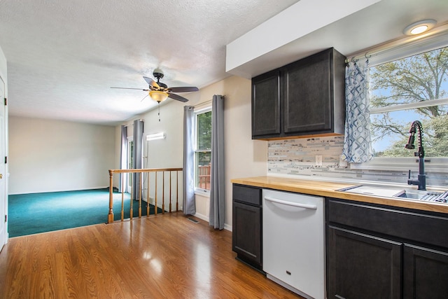 kitchen featuring carpet flooring, wood counters, backsplash, sink, and dishwasher