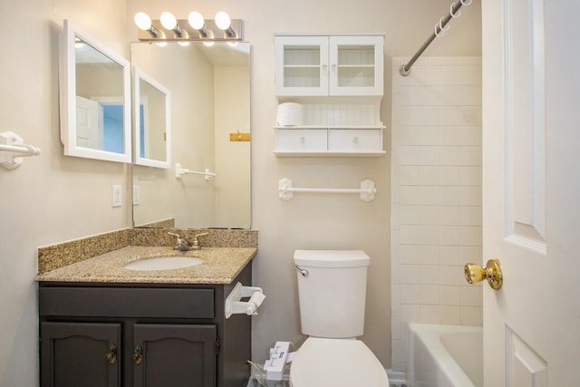 full bathroom featuring tiled shower / bath combo, vanity, and toilet