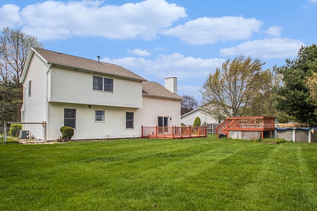 rear view of property featuring a yard and a deck