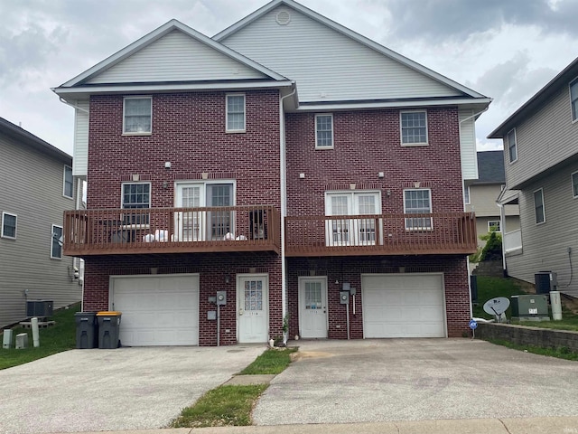 view of front facade featuring central AC, a balcony, and a garage