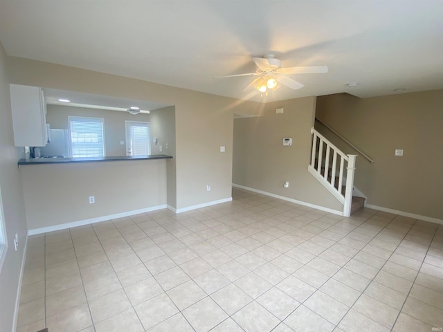 unfurnished room with ceiling fan and light tile floors