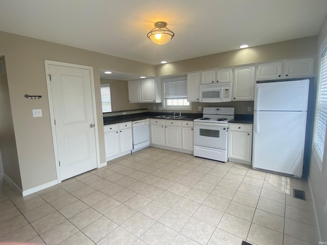 kitchen with sink, white appliances, and light tile floors