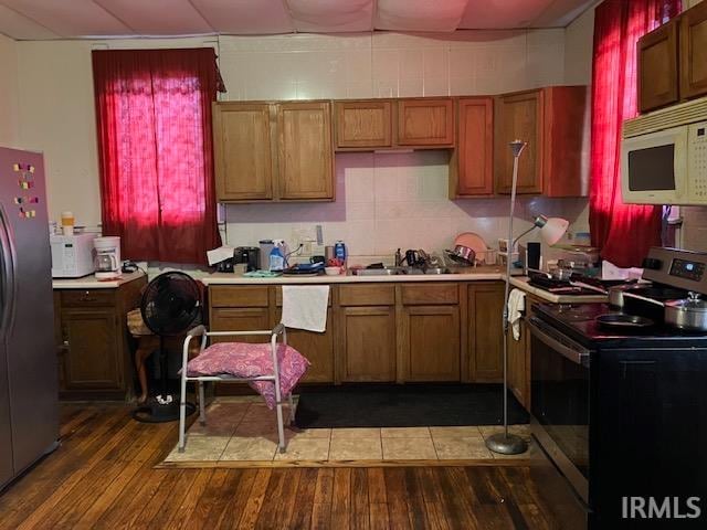 kitchen with hardwood / wood-style floors, stainless steel appliances, and sink