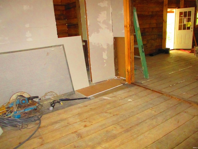 empty room with hardwood / wood-style flooring and wooden walls