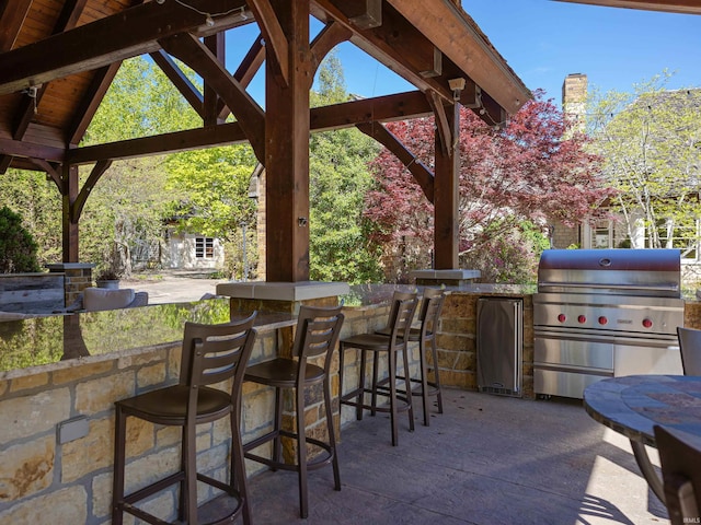 view of terrace featuring grilling area, a bar, and area for grilling