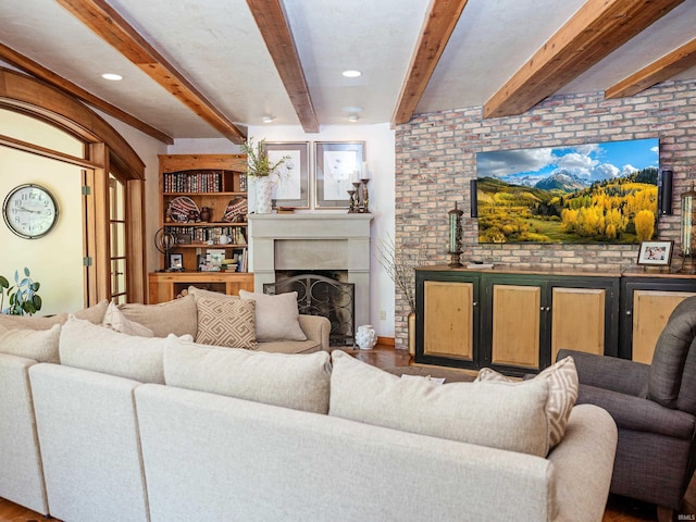 living room with brick wall, beam ceiling, and hardwood / wood-style flooring