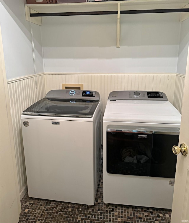 laundry room with dark tile floors, washer hookup, and washer and clothes dryer