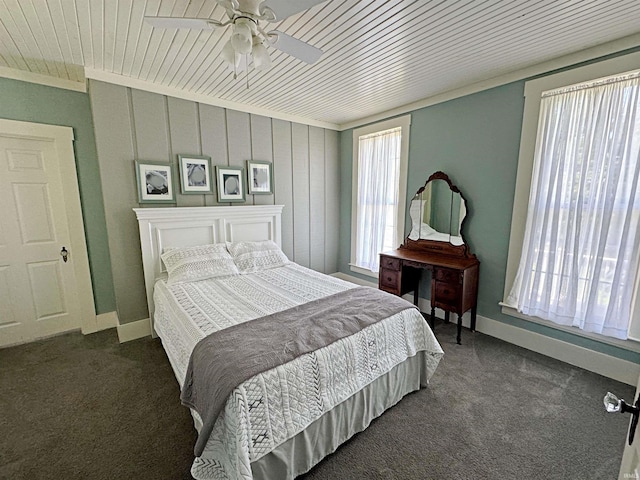 bedroom featuring wood ceiling, dark colored carpet, crown molding, and ceiling fan