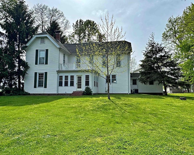 exterior space with a balcony, central air condition unit, and a lawn