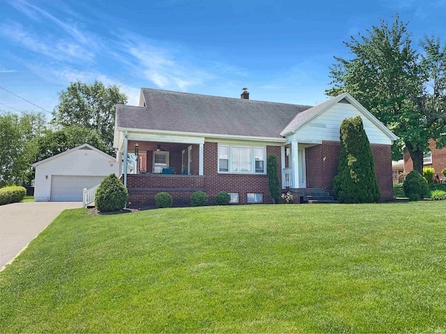 view of front facade with a porch, a front yard, an outbuilding, and a garage