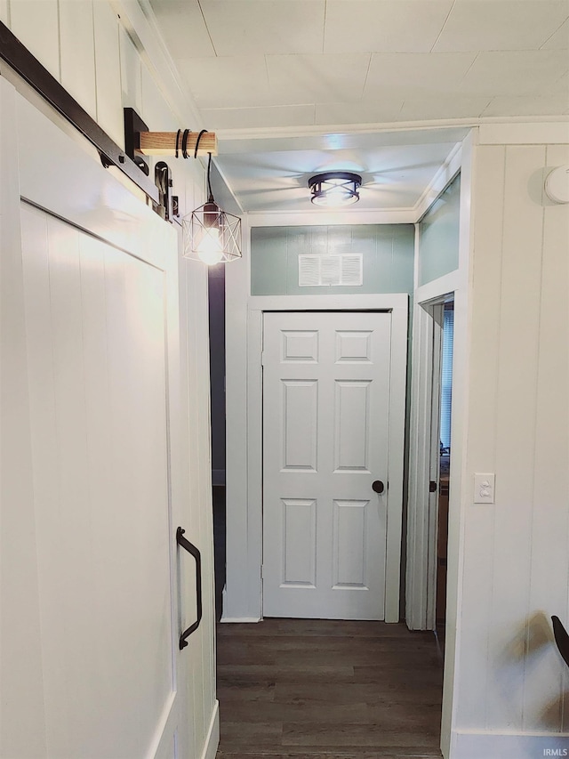 doorway featuring ornamental molding and dark wood-type flooring