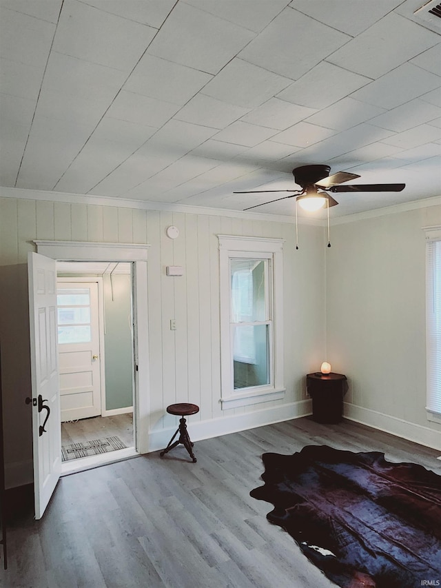 interior space featuring ornamental molding, wood-type flooring, and ceiling fan