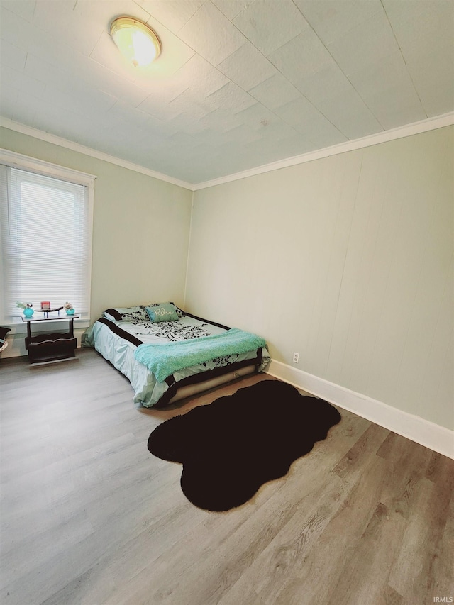 bedroom with crown molding and hardwood / wood-style floors