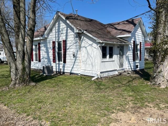 view of side of home featuring a yard and central air condition unit