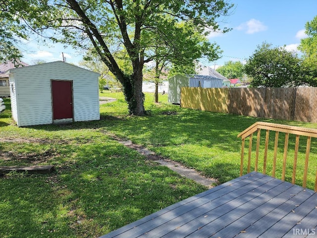 view of yard featuring a wooden deck and a storage shed