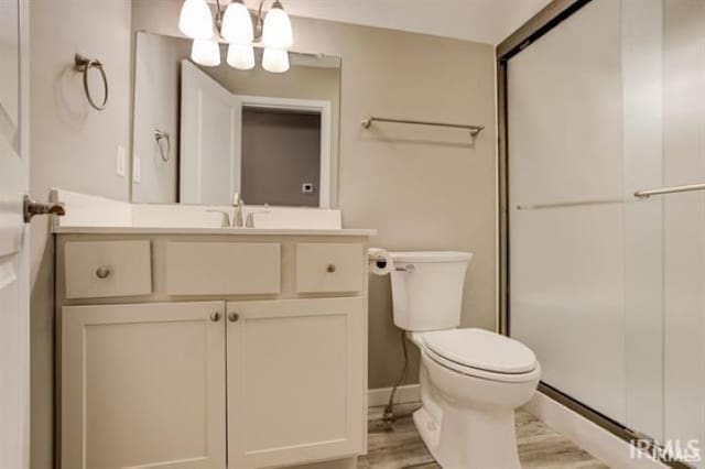 bathroom featuring vanity, a notable chandelier, wood-type flooring, and toilet