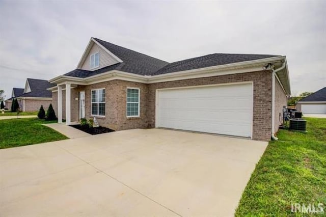 view of front facade with central AC, a garage, and a front lawn