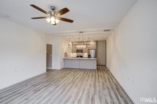 unfurnished living room featuring ceiling fan and light hardwood / wood-style flooring