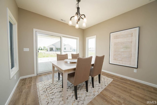 dining space featuring hardwood / wood-style flooring and a chandelier