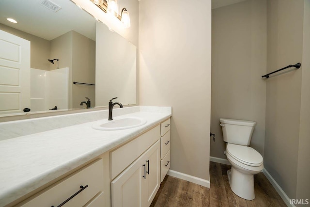 bathroom featuring vanity, hardwood / wood-style flooring, and toilet