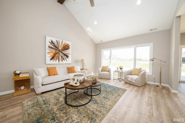 living room featuring high vaulted ceiling and light wood-type flooring