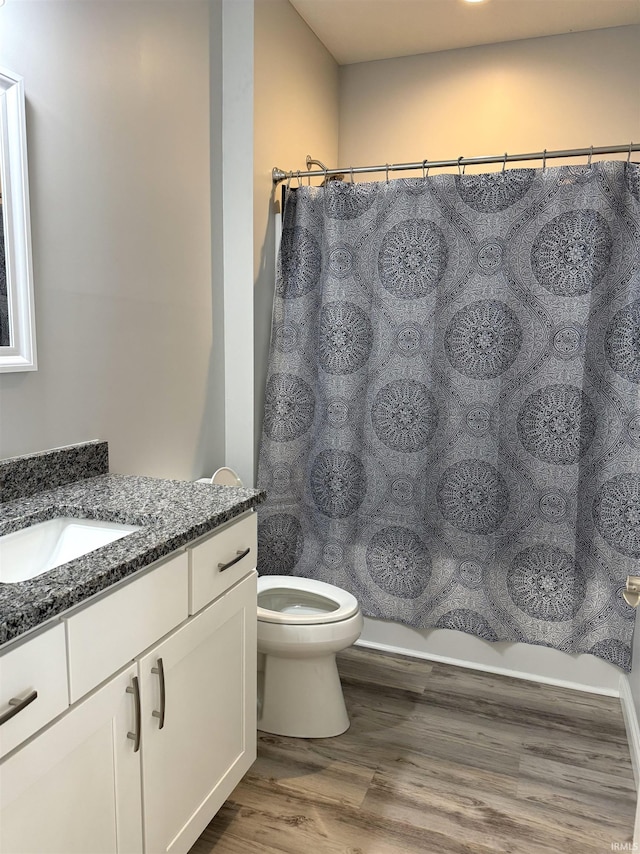 bathroom with toilet, hardwood / wood-style floors, and vanity