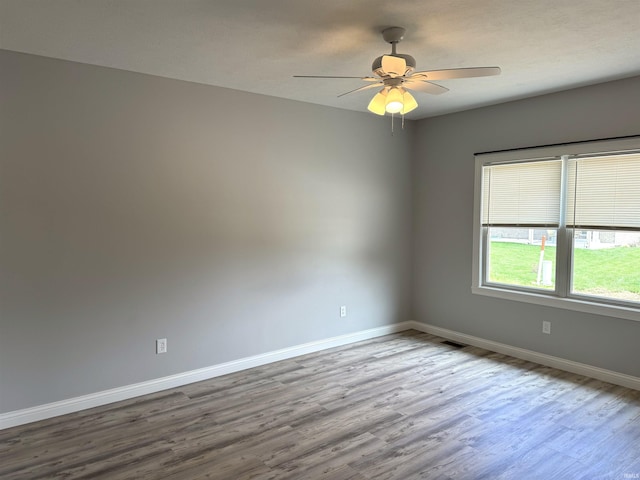 spare room with hardwood / wood-style flooring and ceiling fan