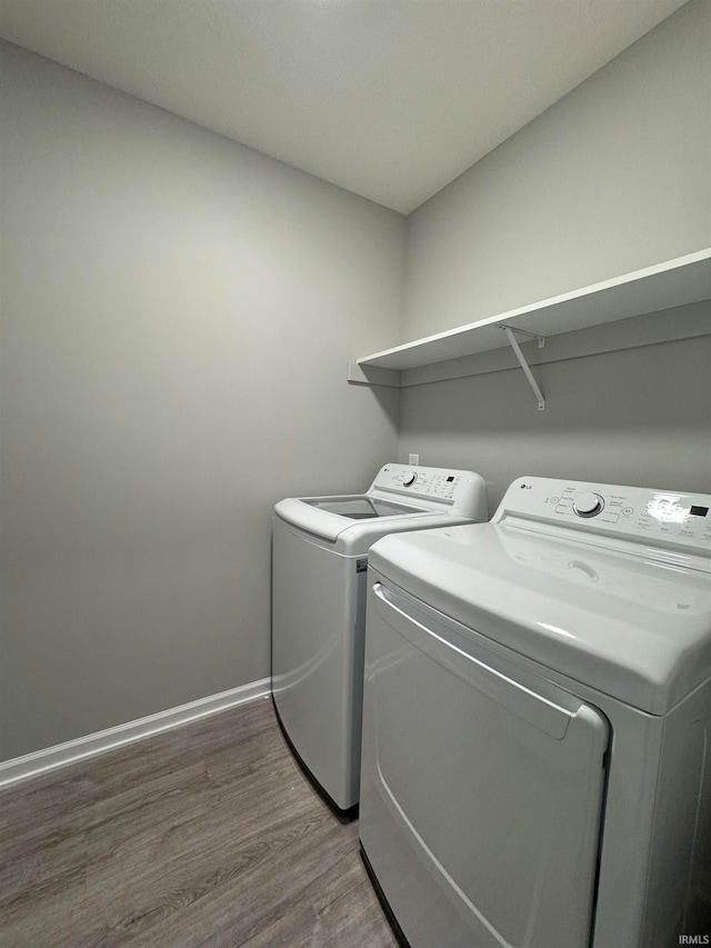 laundry room with hardwood / wood-style flooring and washer and dryer