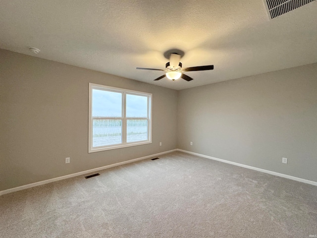 carpeted spare room featuring a textured ceiling and ceiling fan