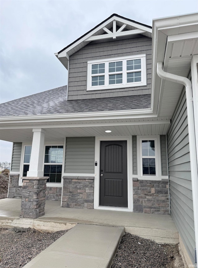 view of exterior entry featuring covered porch