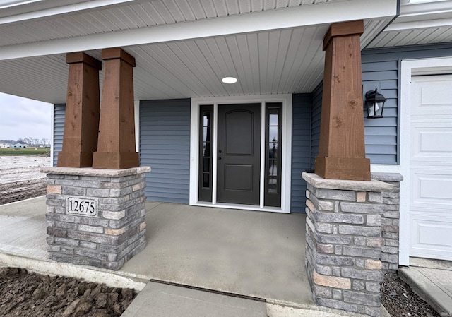 view of exterior entry featuring covered porch