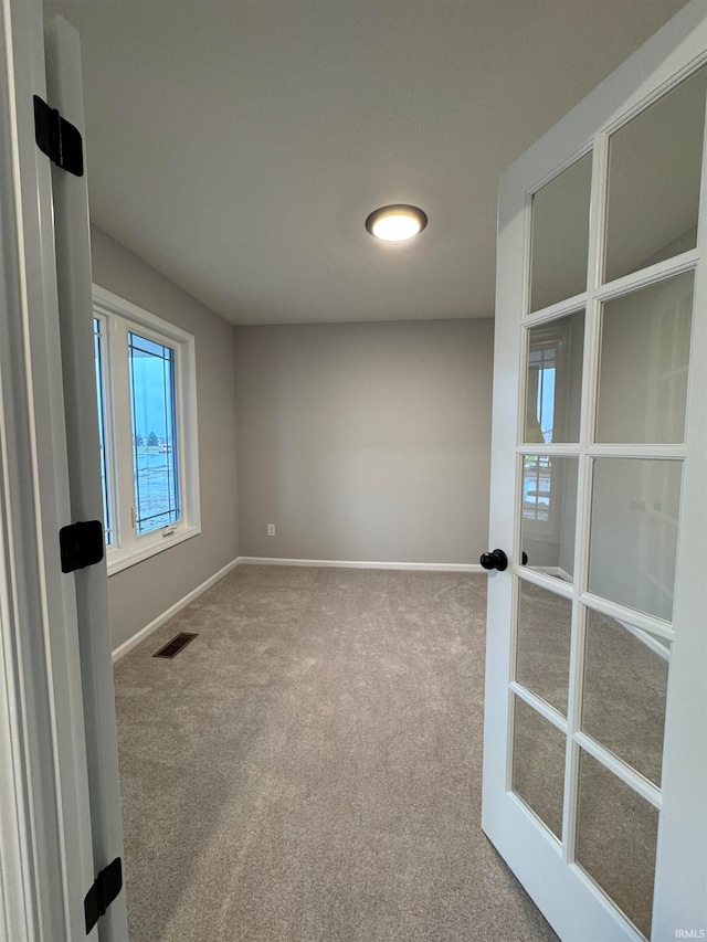 carpeted empty room with french doors