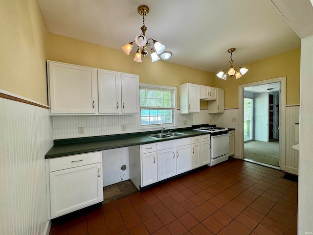 kitchen featuring pendant lighting, a chandelier, sink, range with gas cooktop, and dark tile flooring