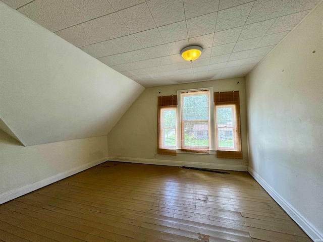 additional living space featuring hardwood / wood-style flooring and lofted ceiling