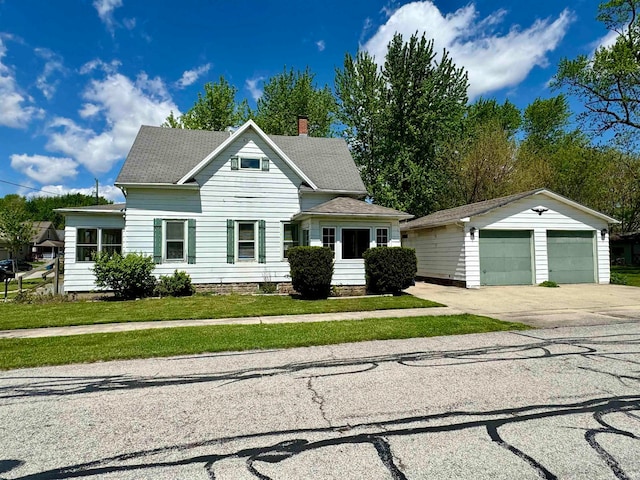 view of front facade featuring an outdoor structure, a garage, and a front yard