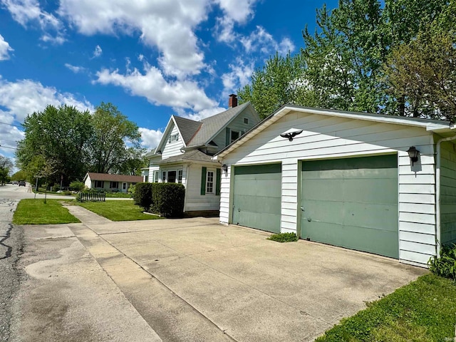 view of front of home featuring an outdoor structure, a garage, and a front yard