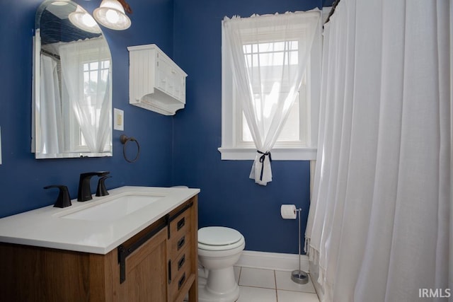 bathroom featuring tile flooring, vanity, and toilet